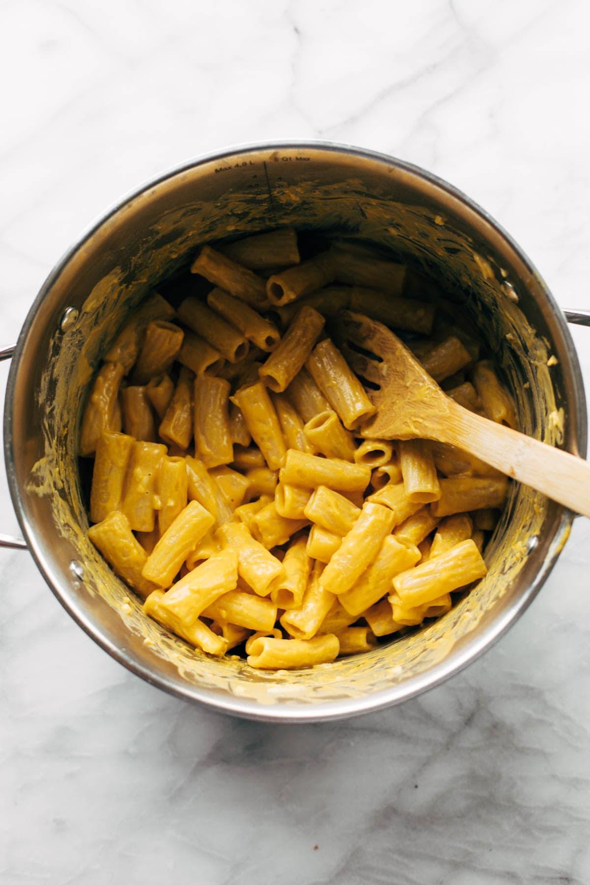 Pumpkin rigatoni mixed in a pot.