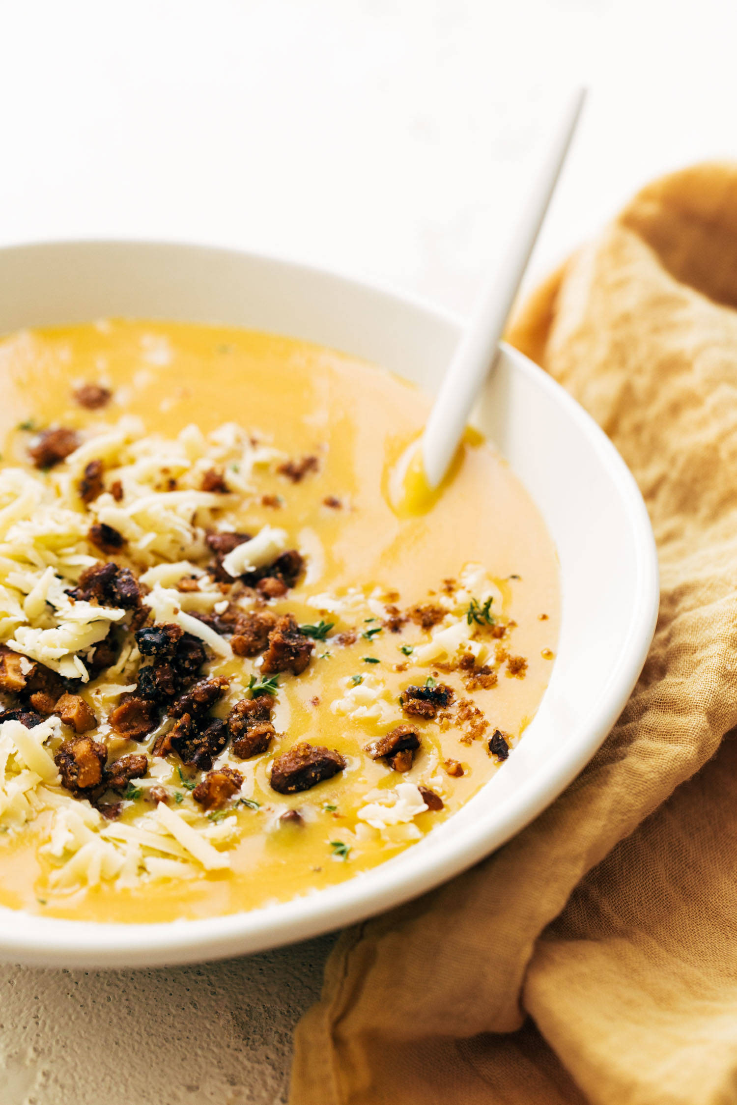 Pumpkin soup in a bowl with walnut crispies.