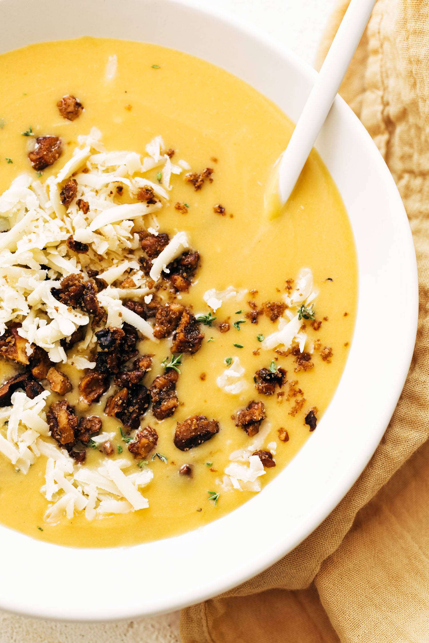 Pumpkin soup in a bowl with walnut crispies and a spoon!