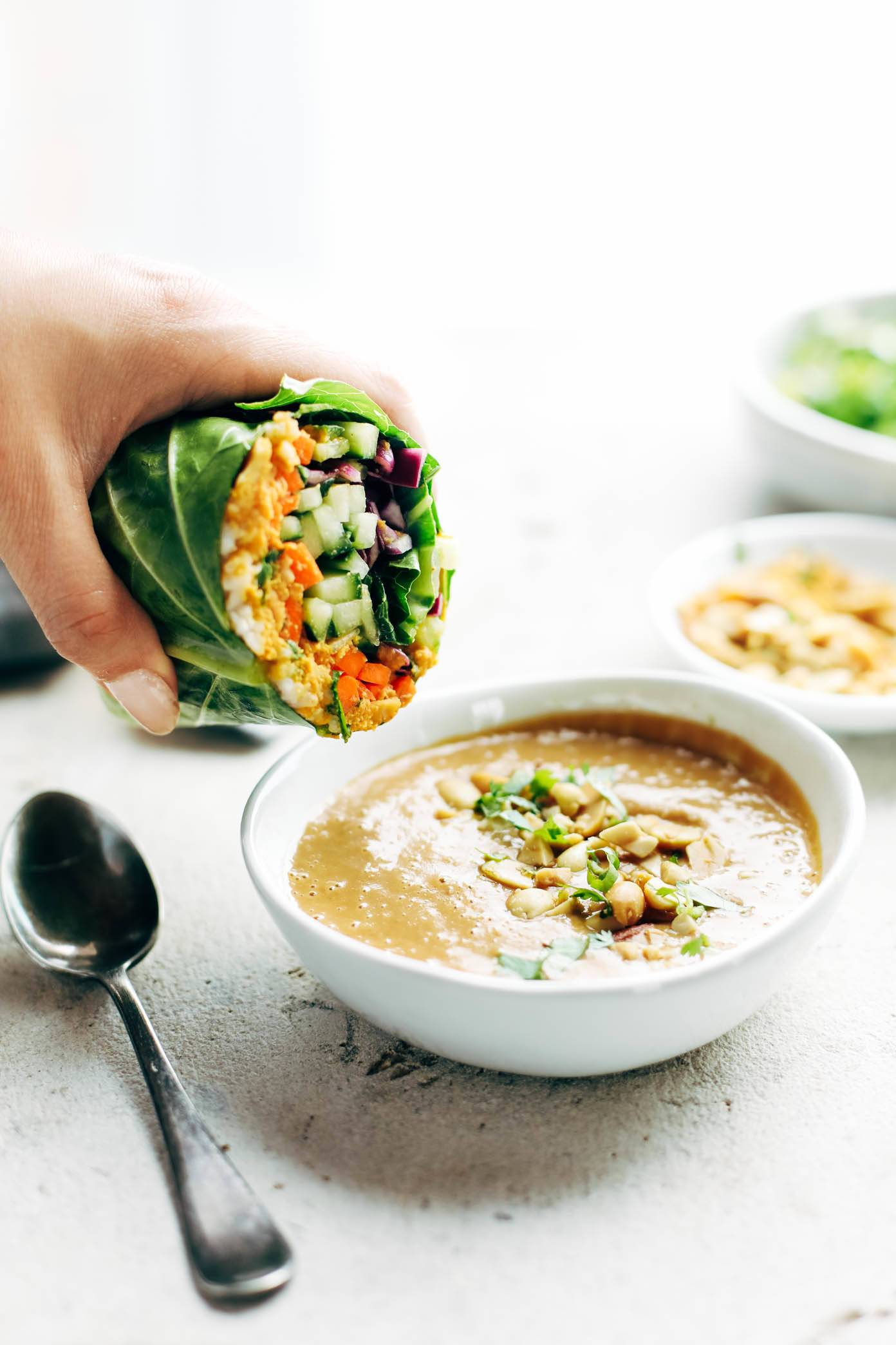 Detox Rainbow Roll-Ups dipped in peanut sauce.