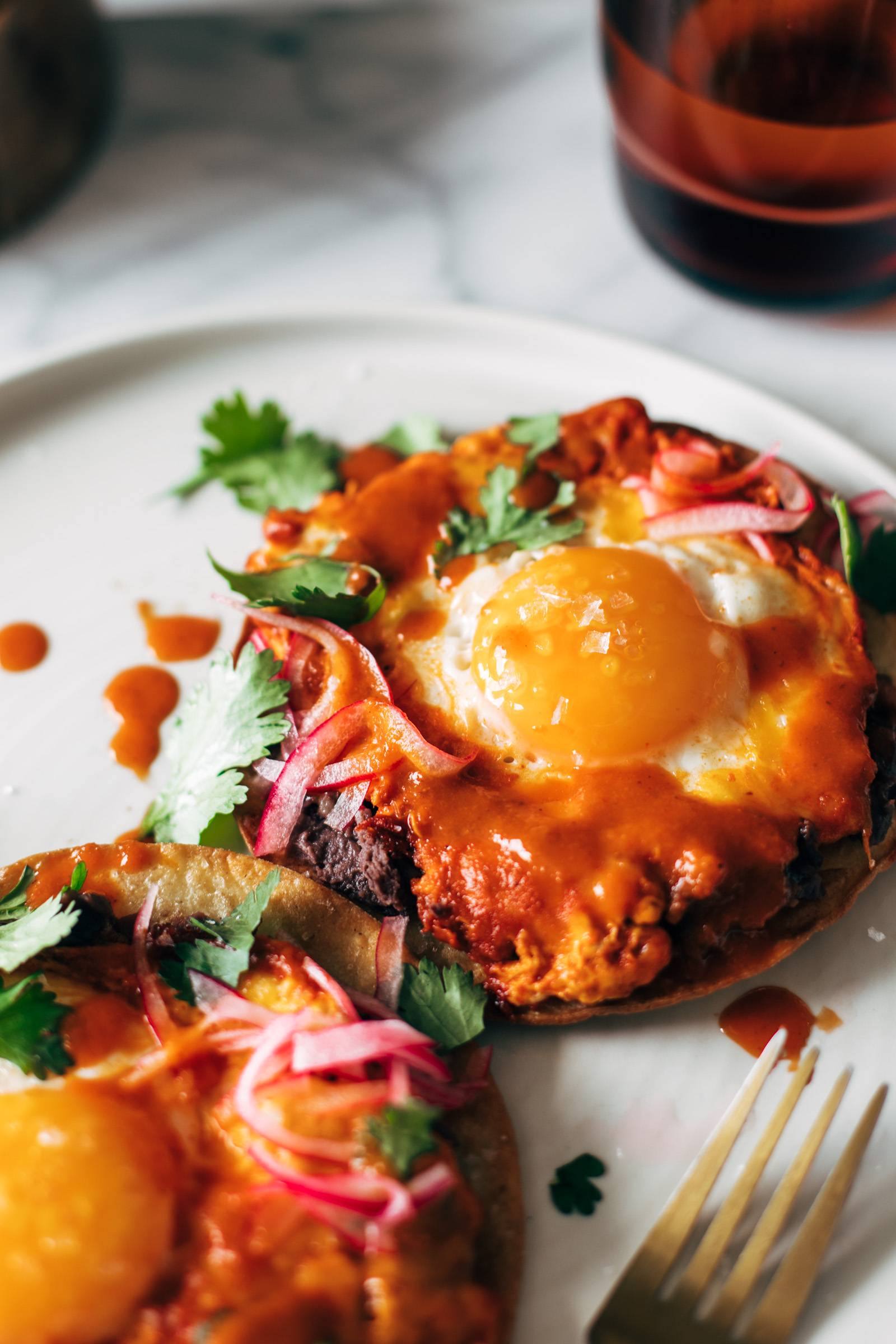 Close-up of red chile tostadas on a plate with eggs.