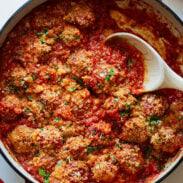 Meatballs in a skillet with red sauce.