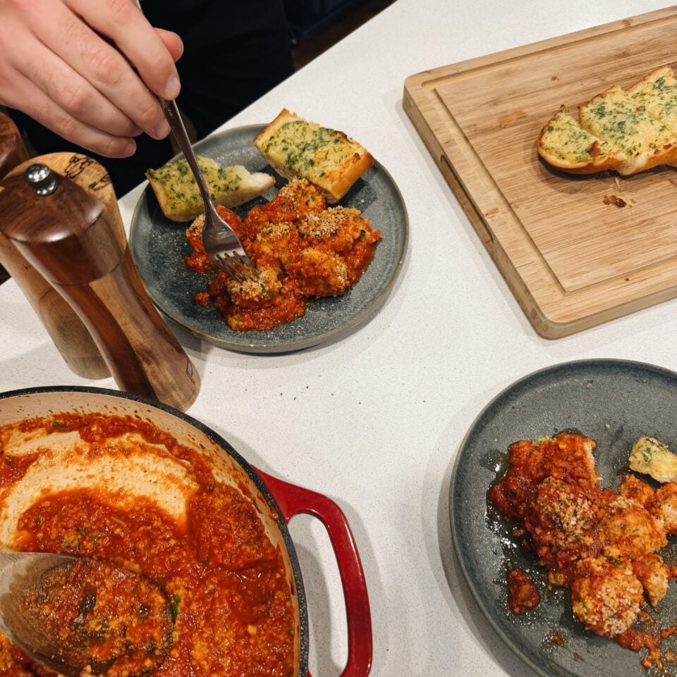 Ricotta meatballs on plates with garlic bread.