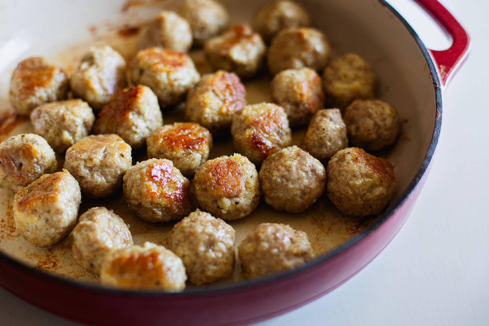 Browned meatballs in a skillet.