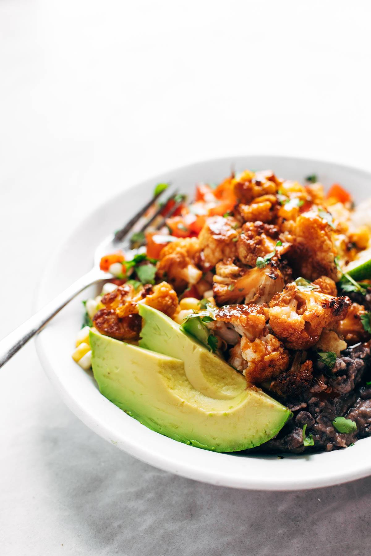 Cauliflower Burrito Bowl with avocado slices.