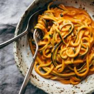 Roasted red pepper pasta in a bowl with zucchini noodles.