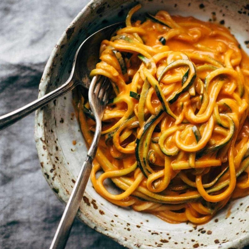 Roasted red pepper pasta in a bowl with zucchini noodles.