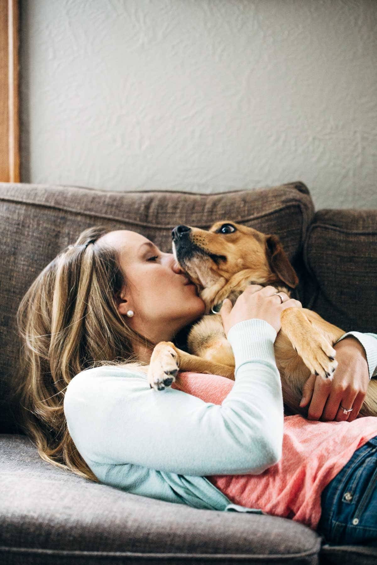 Woman kissing a dog.