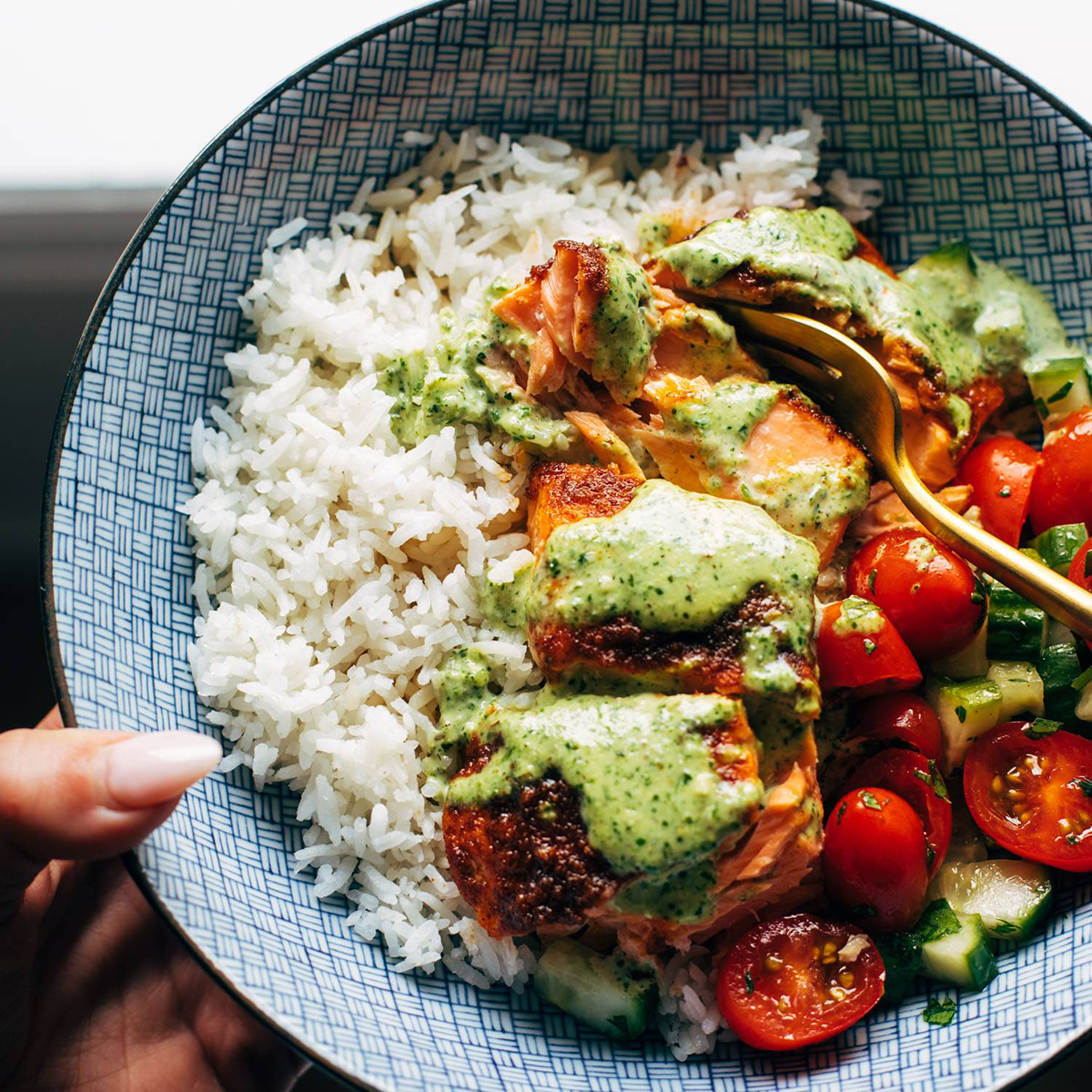 Salmon in a bowl with rice and basil sauce.