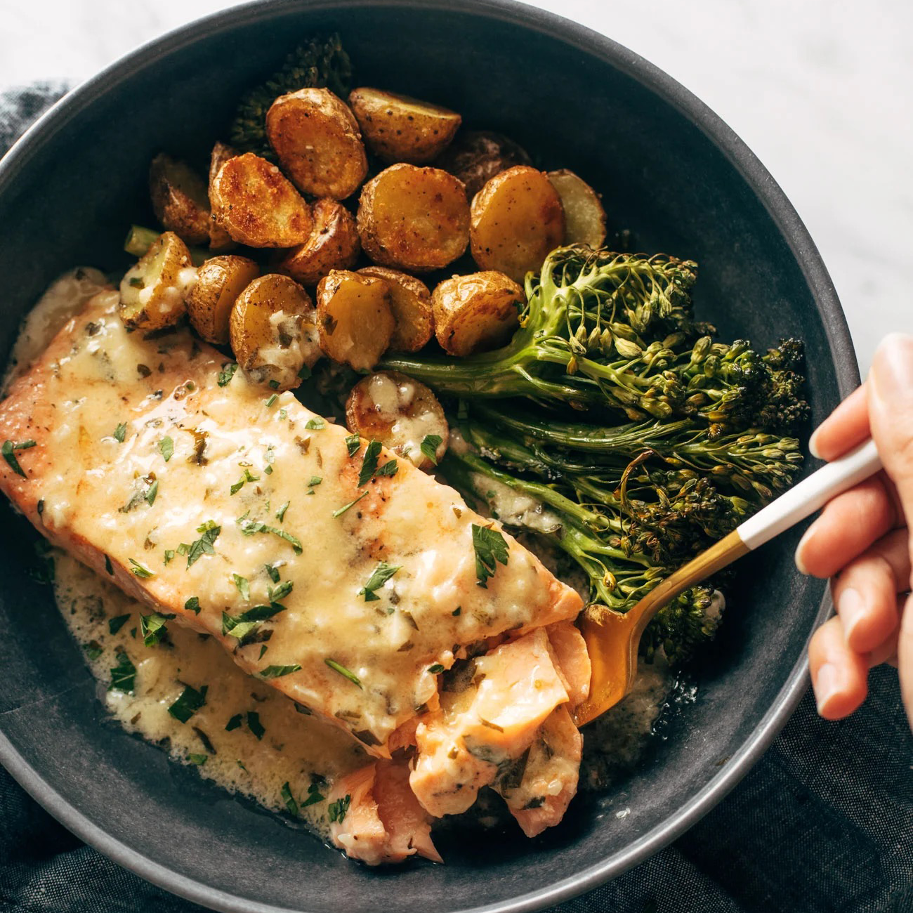 Salmon with lemon, broccoli, and sauce.