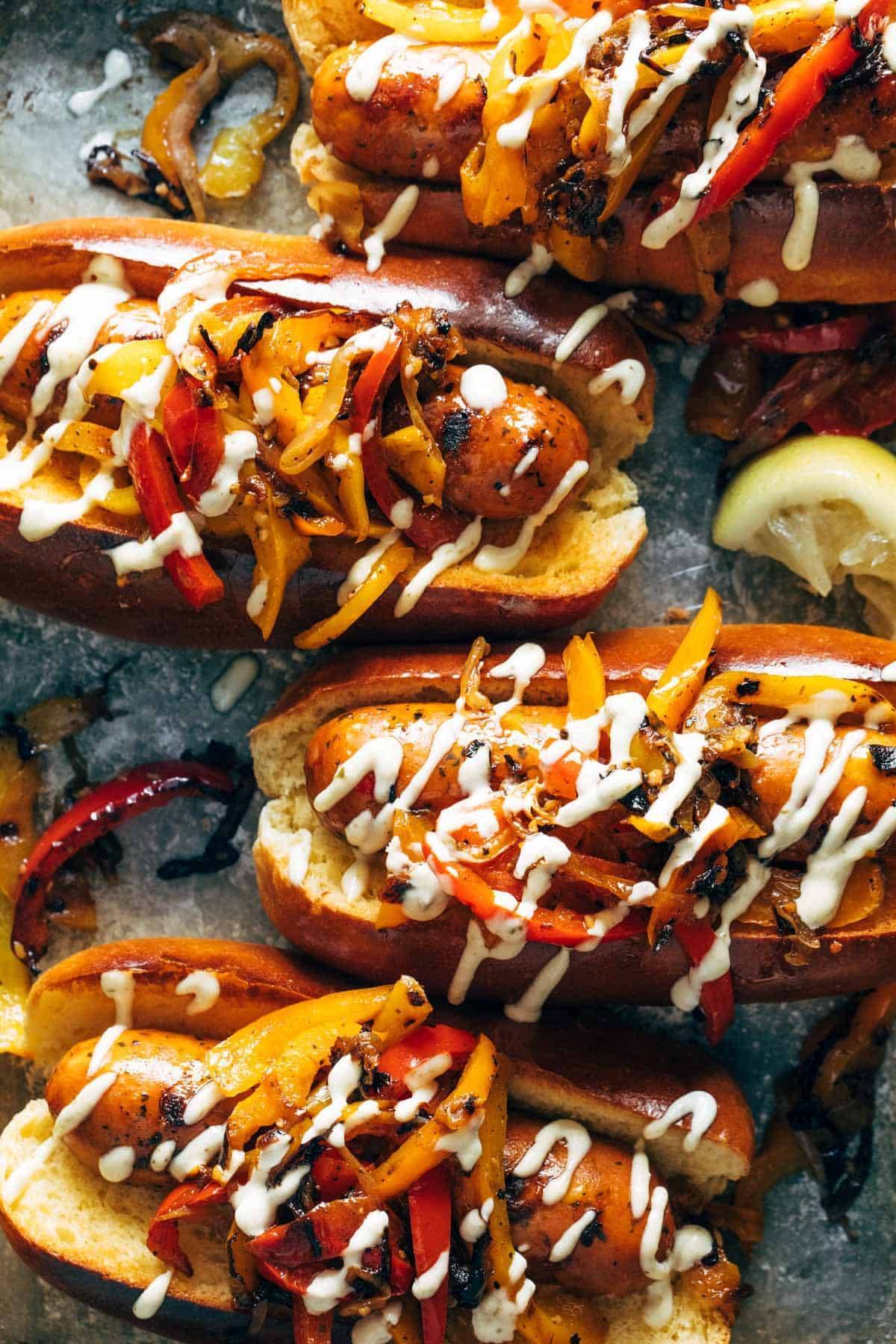 Grilled sausage and peppers with aioli on a sheet pan.