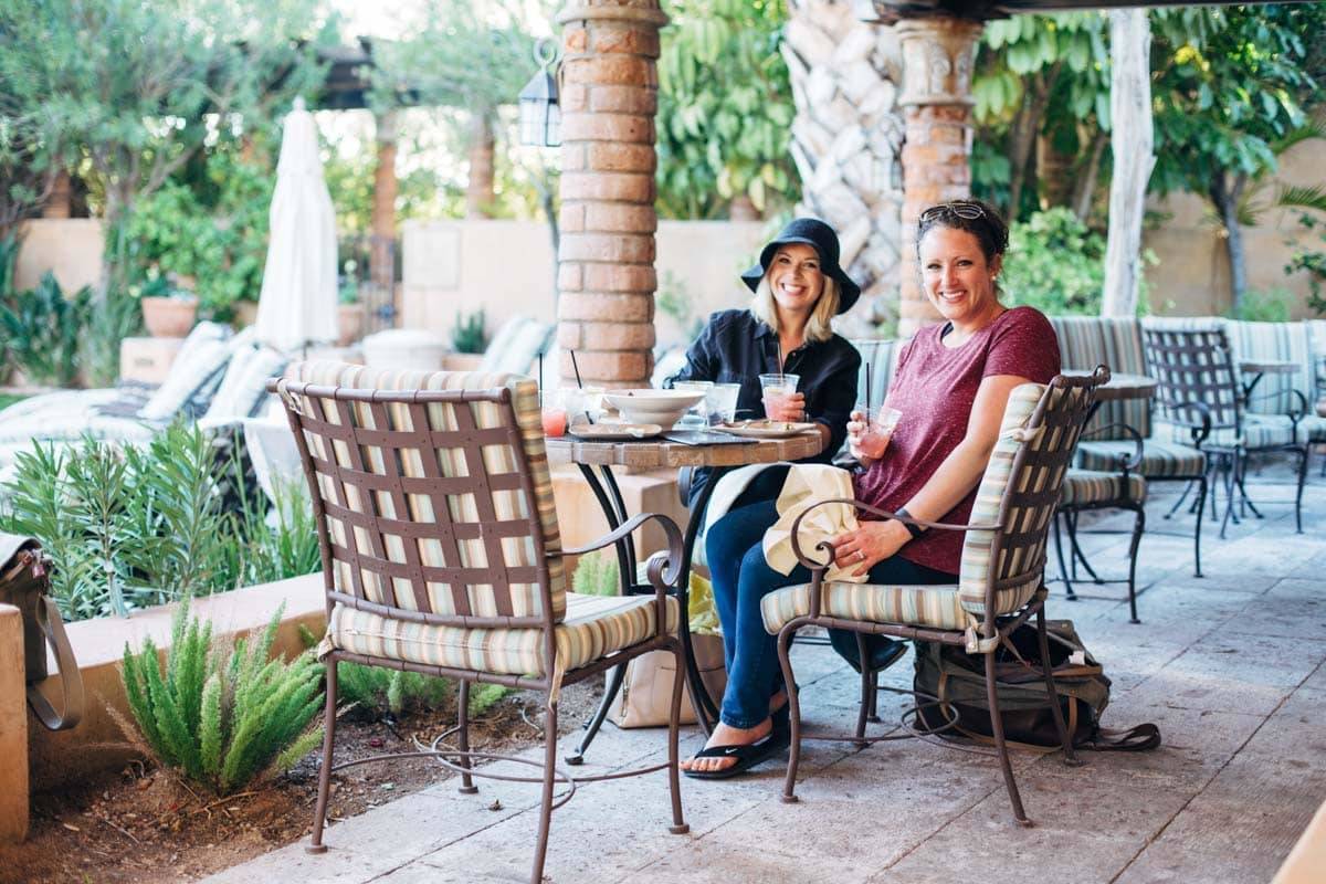 girls sitting in chairs on a patio