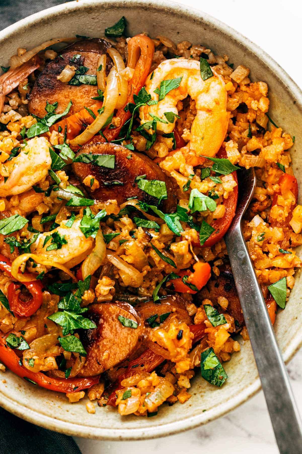 Rice and sausage in a bowl with a spoon.