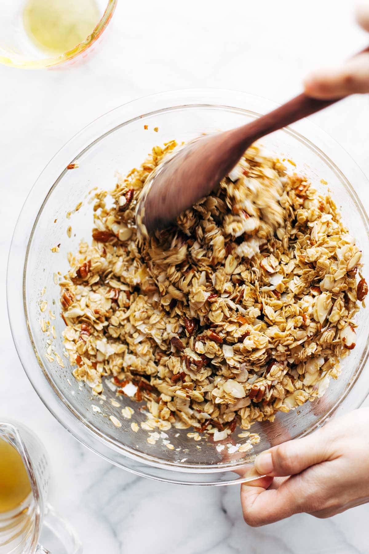 Mixing up granola ingredients with wooden spoon.