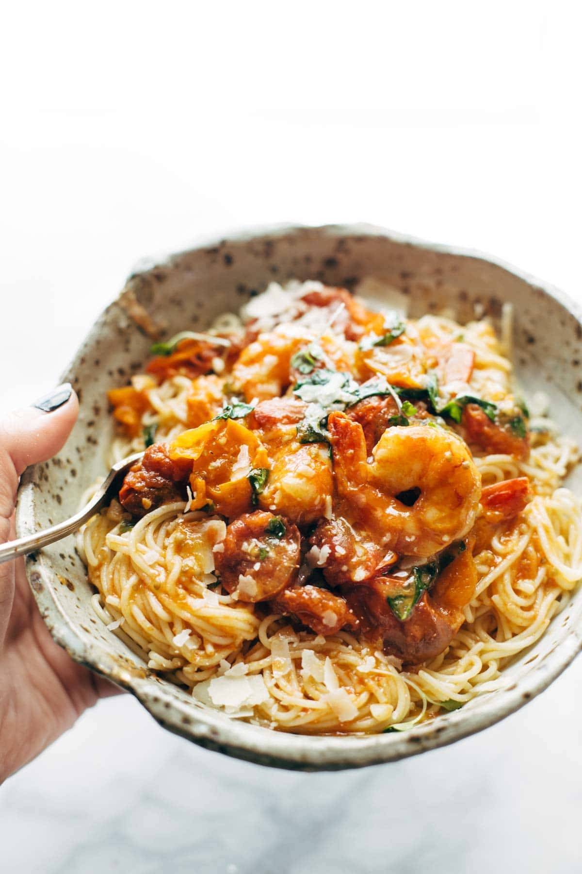 Capellini pomodoro with shrimp in a bowl with a fork.