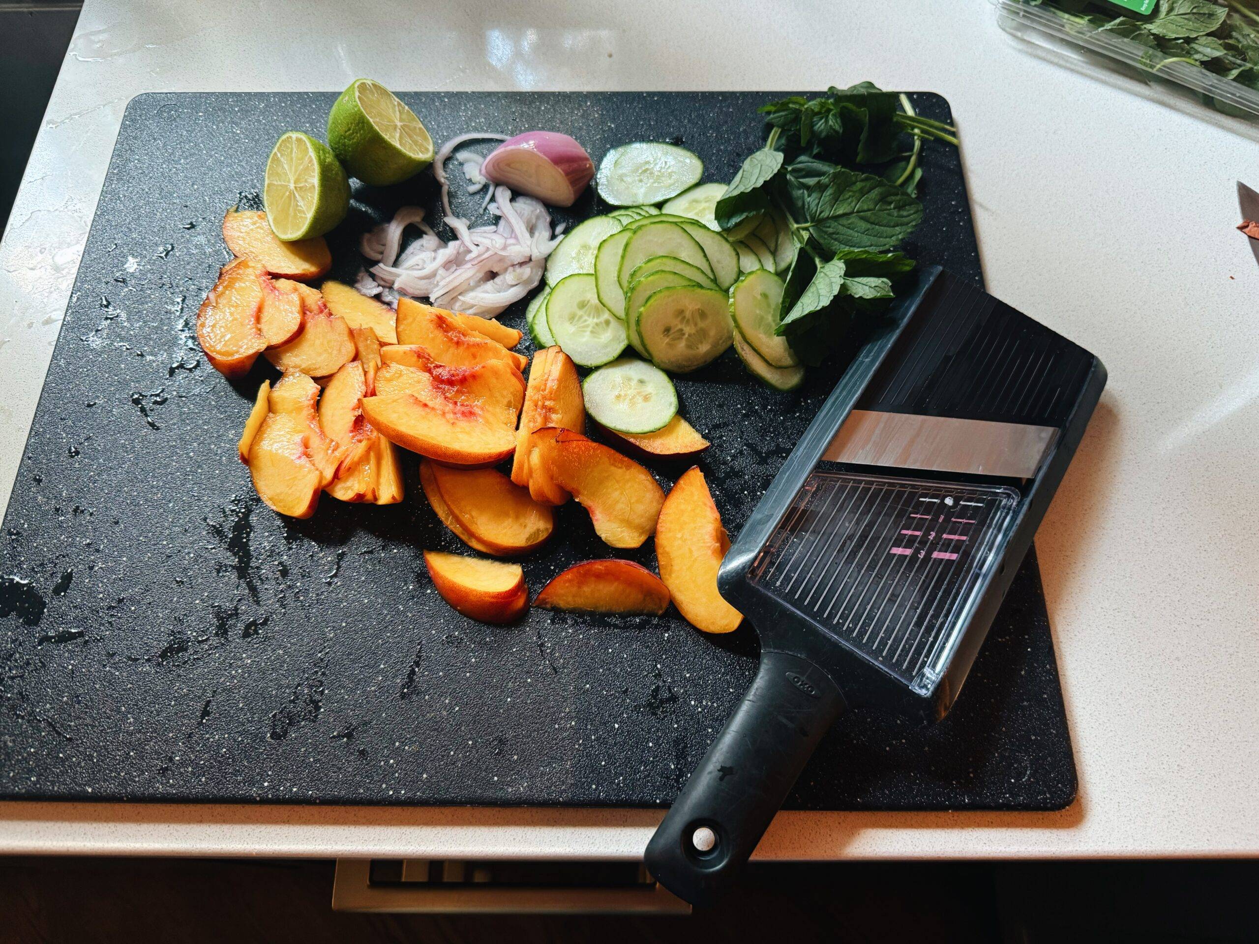 Sliced ingredients no a cutting board for peach salad.