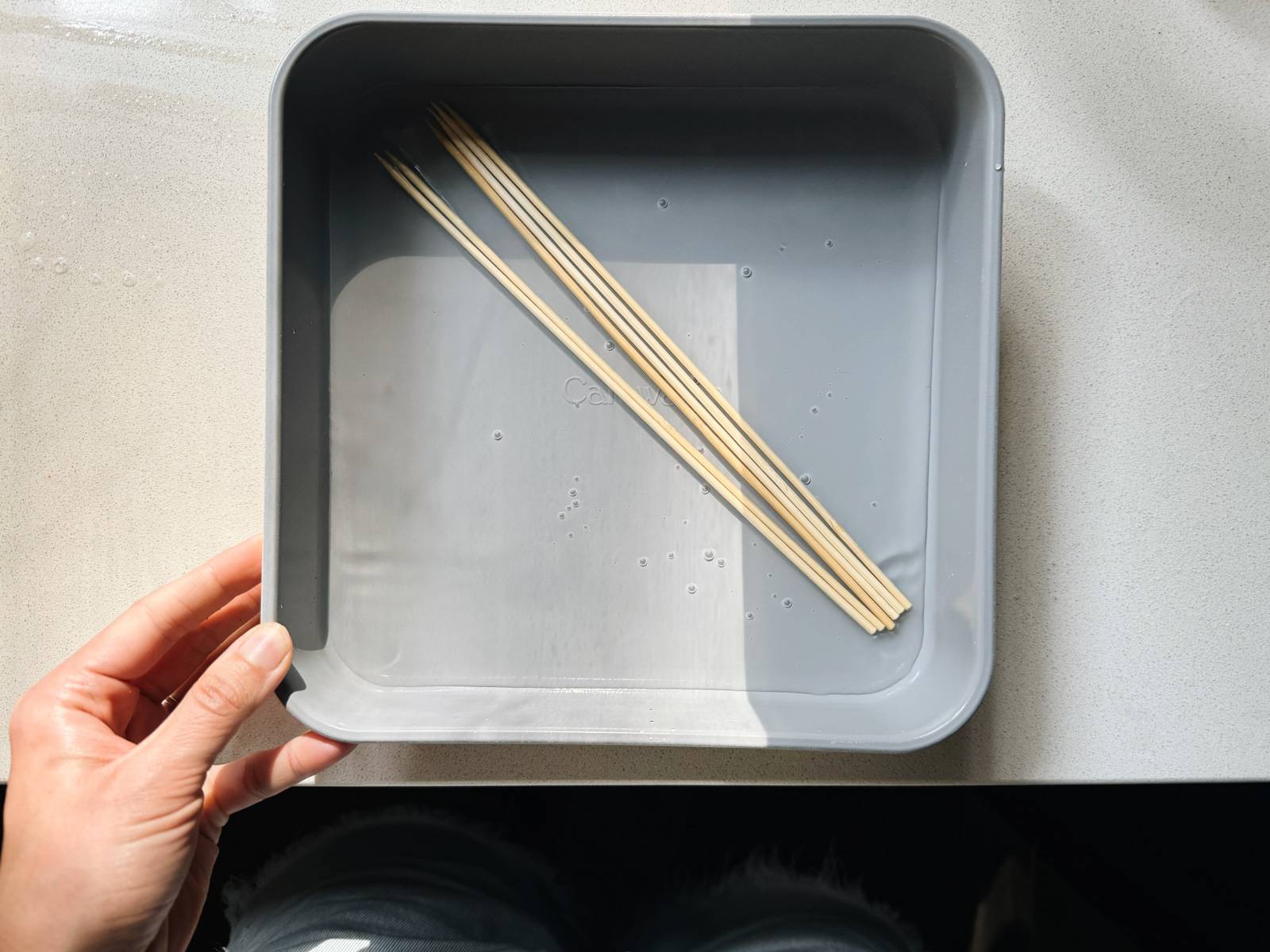 Soaking wooden skewers in water.