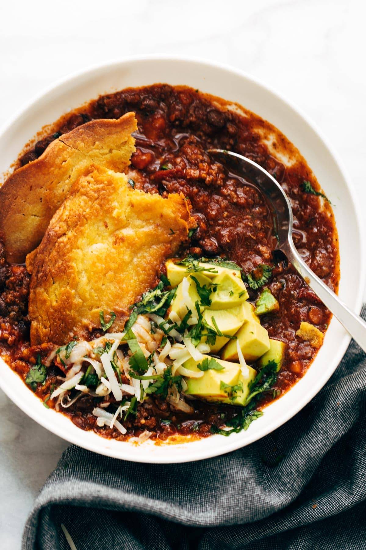 Pieces of socca in a bowl of chili.