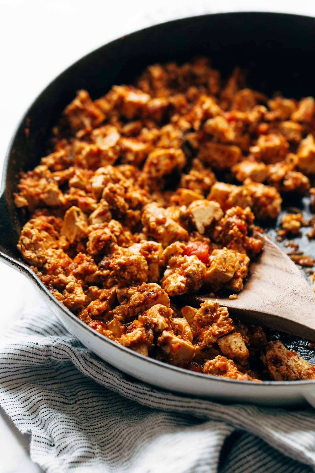 Sofritas being scooped out of a pan with a wooden spoon