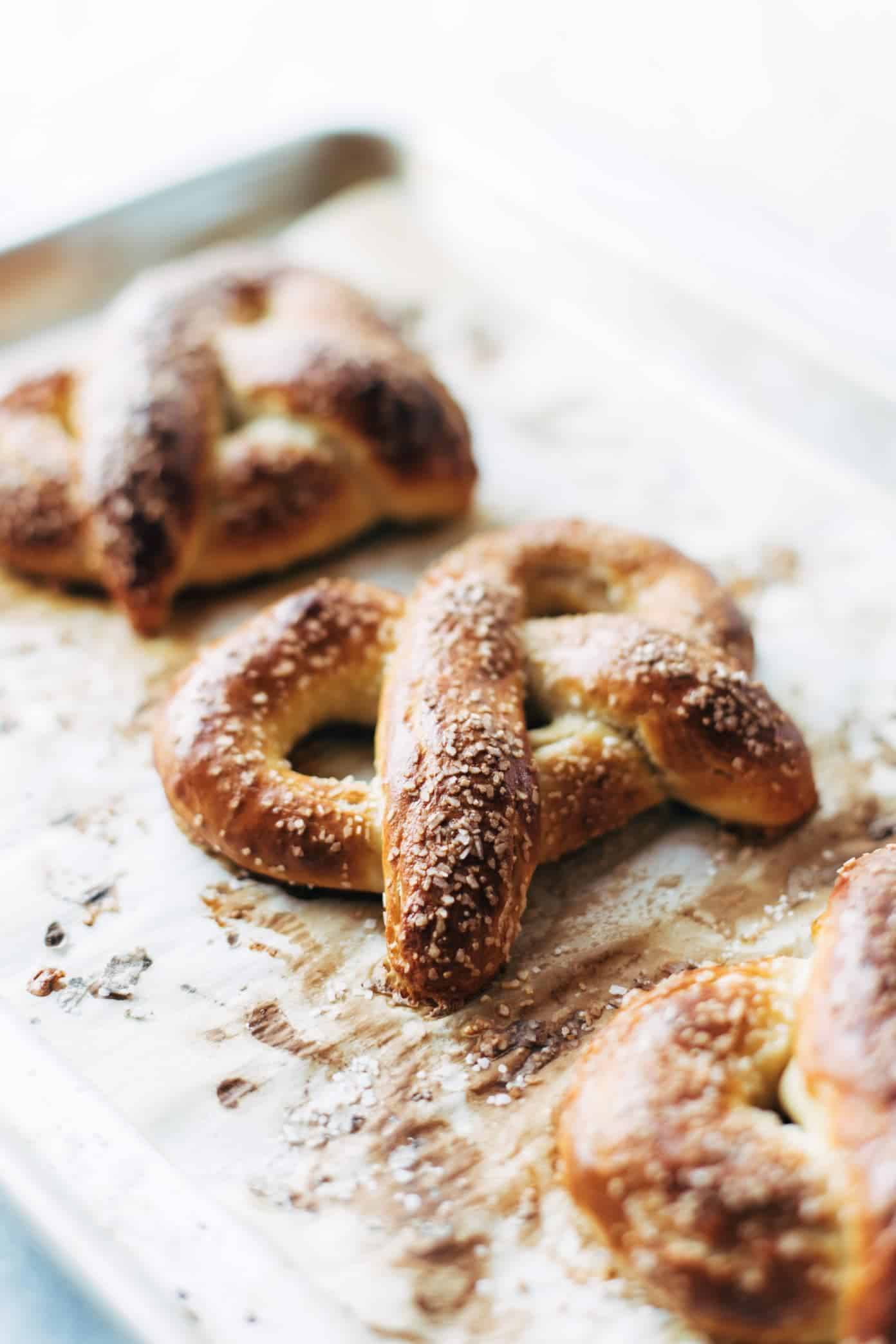 Baked soft pretzels on pan.