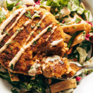 Salmon burgers on a plate with a salad.