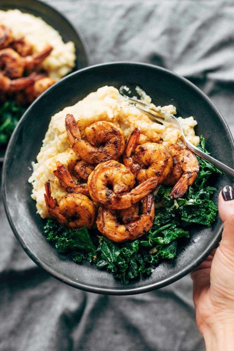 Spicy shrimp on a plate with mashed cauliflower and kale.