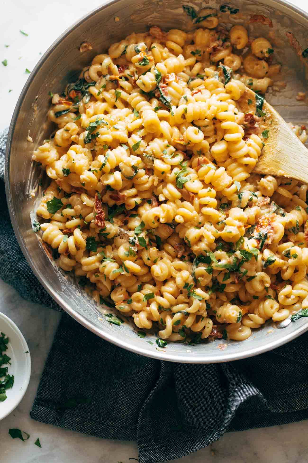 Creamy Garlic Sun-Dried Tomato Pasta in a pan with a wooden spoon