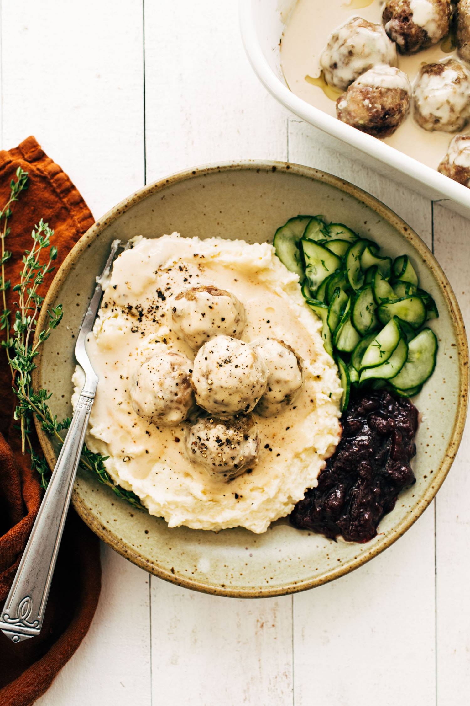 Swedish meatballs with cucumbers and cranberries in a bowl.