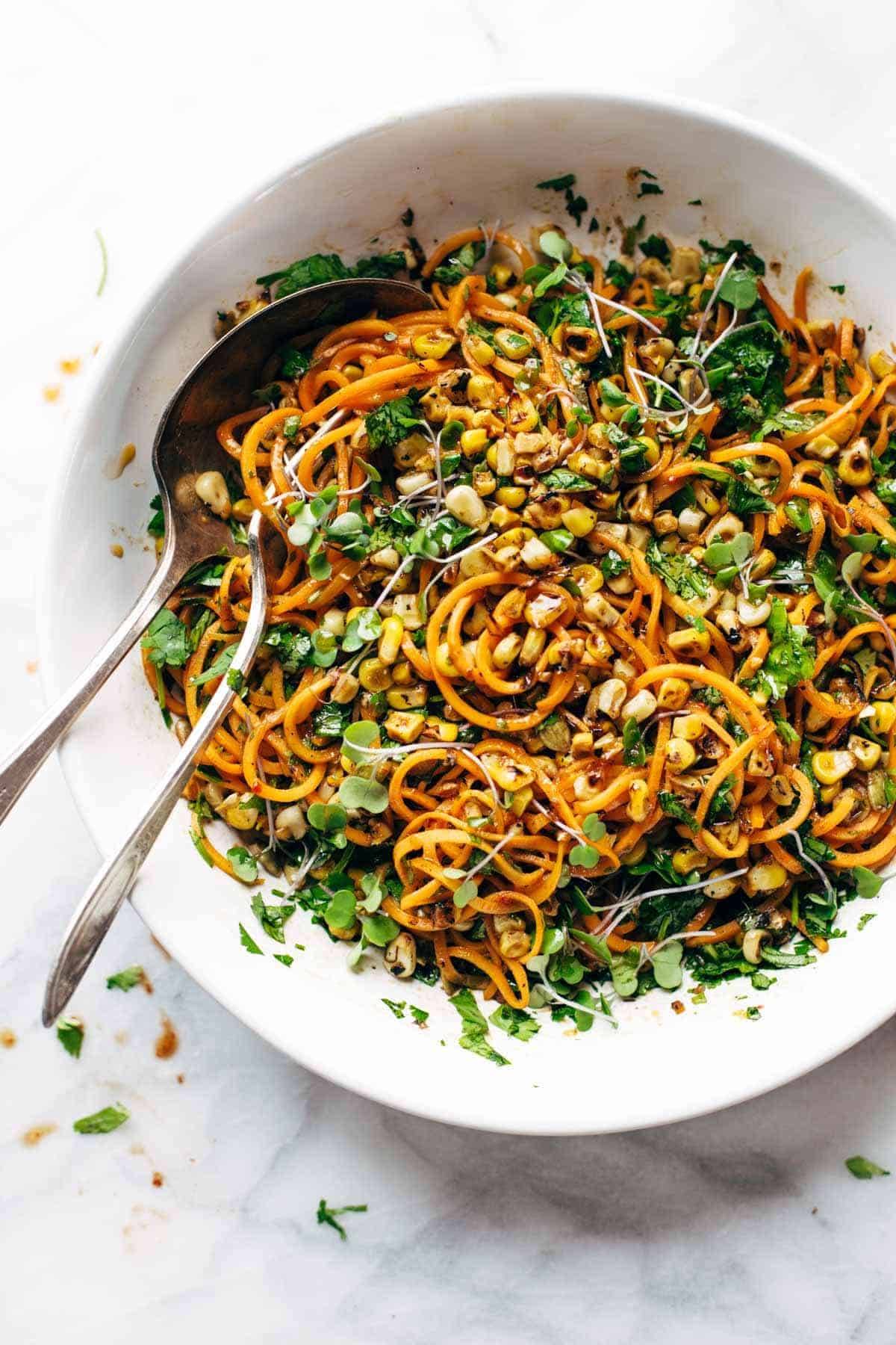 Noodle salad in a bowl with two spoons.