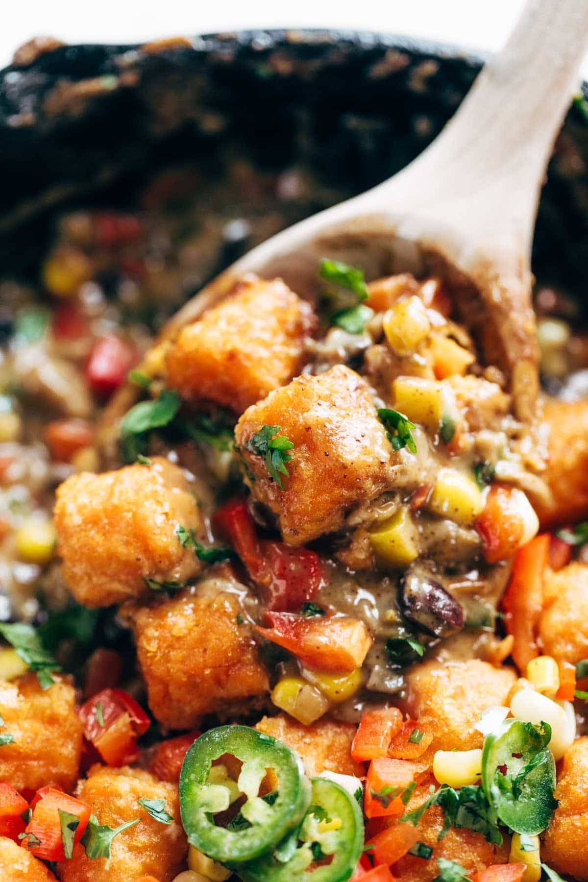 sweet potato tater tot hotdish with a wooden spoon