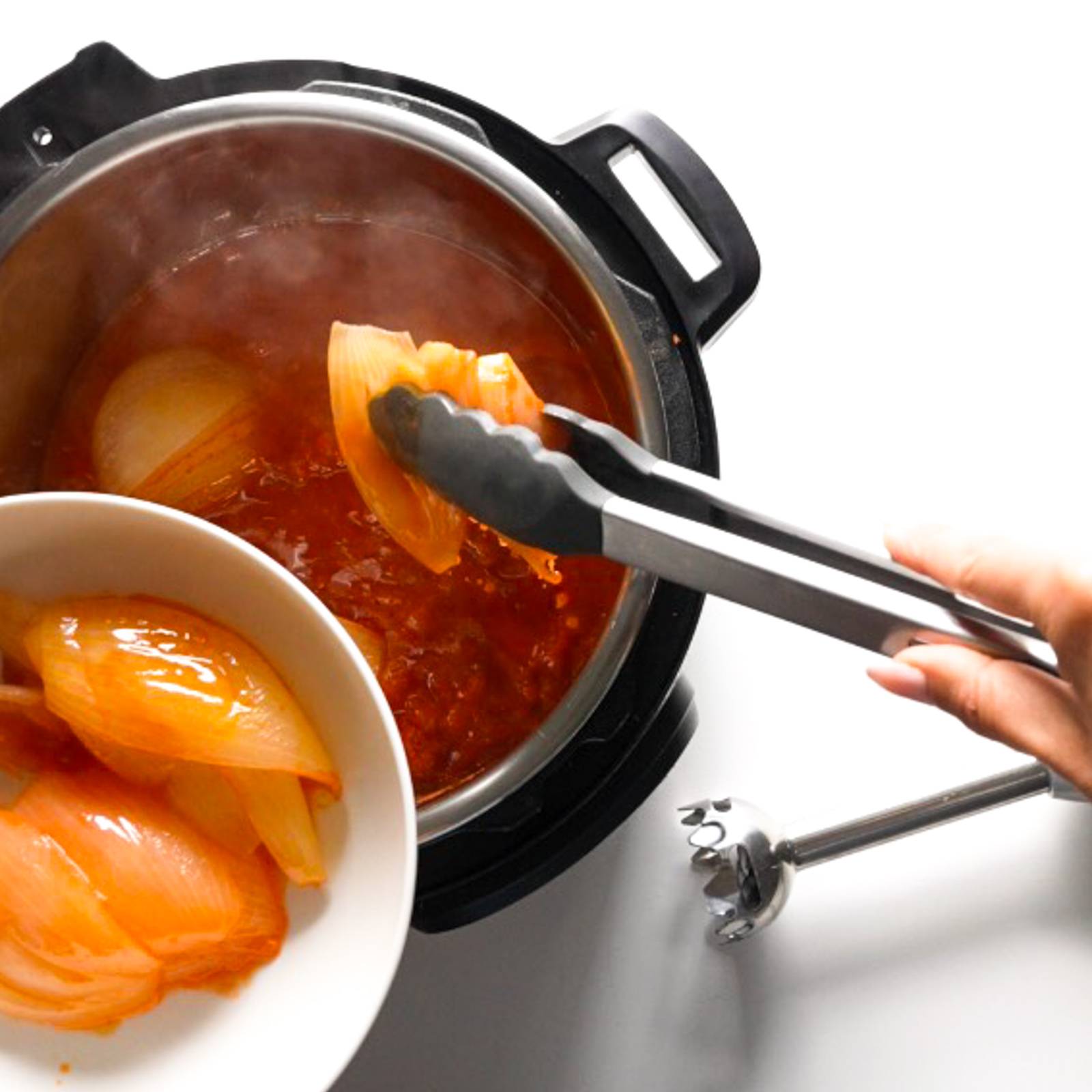 Removing cooked onions from the Instant Pot.