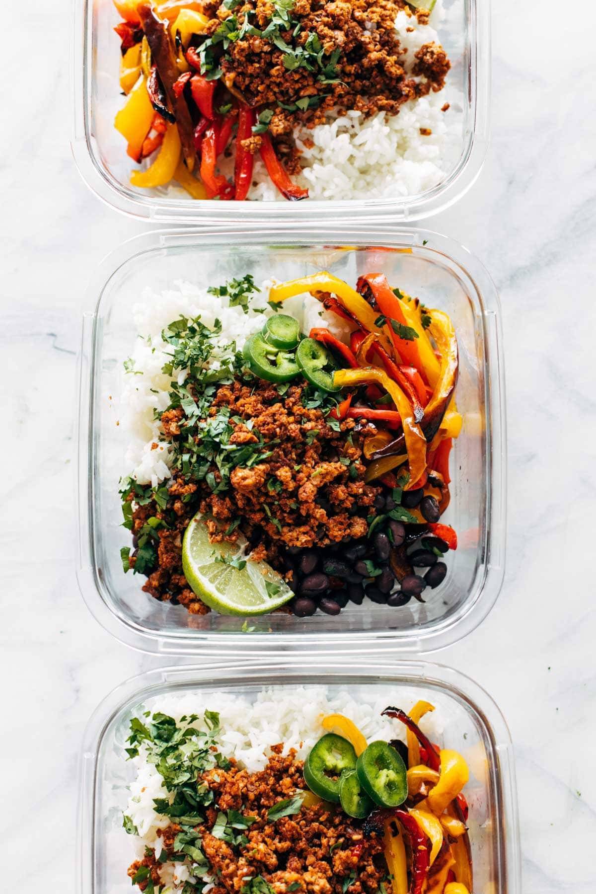 Vegan burrito bowls with rice in glass containers.