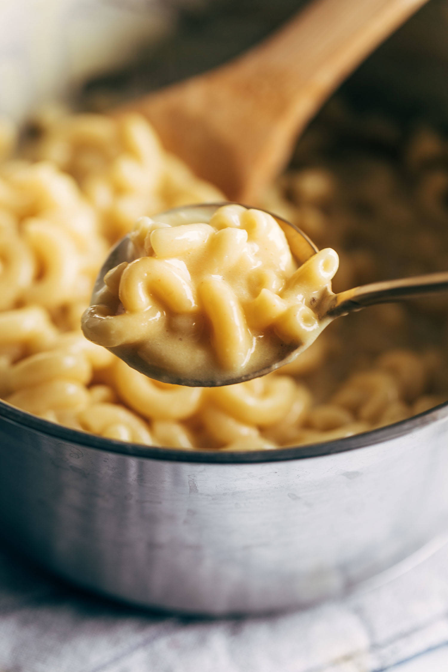 Vegan mac and cheese being scooped up with a spoon.