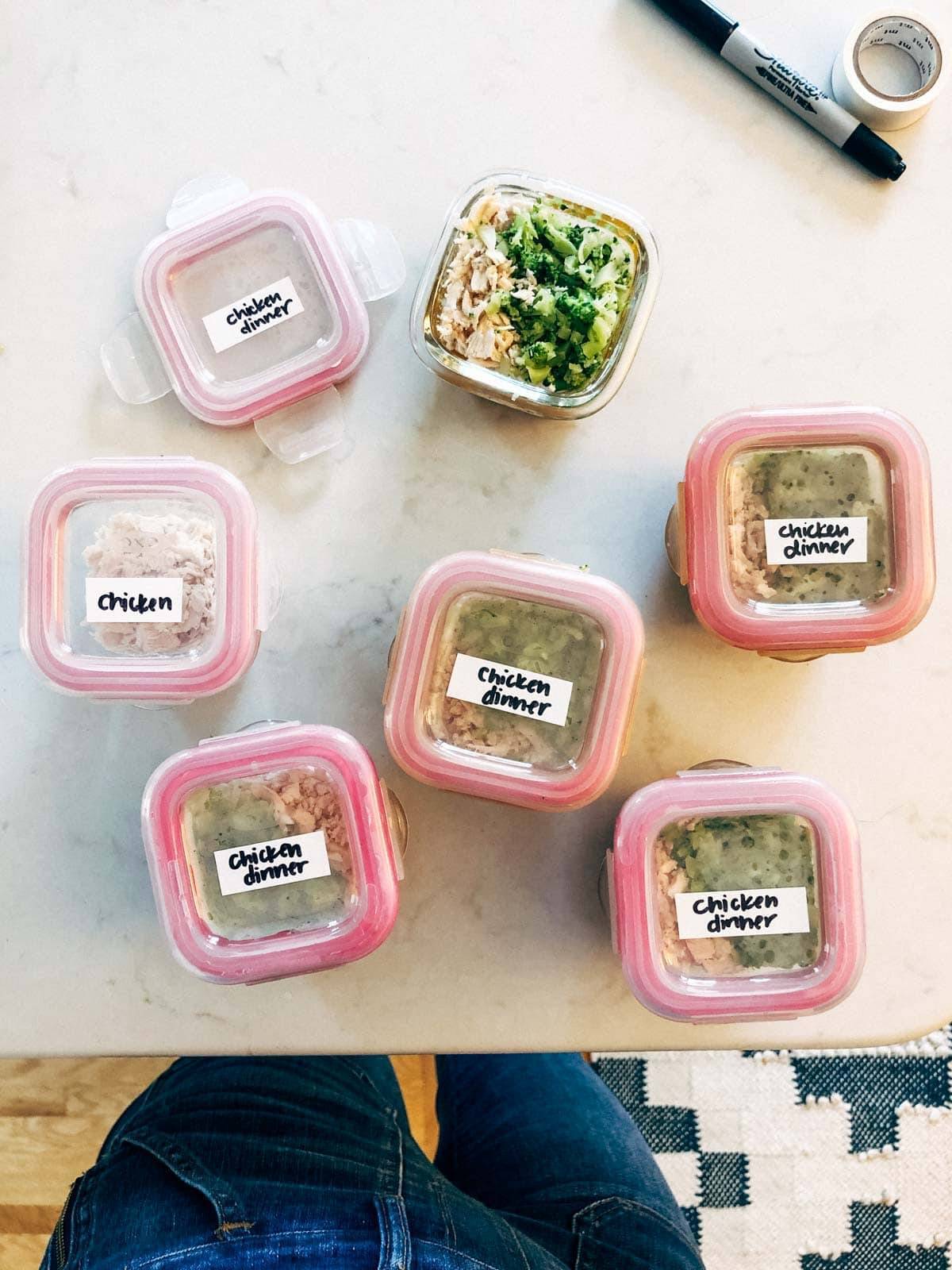 Seven containers of prepped food sitting on a table.