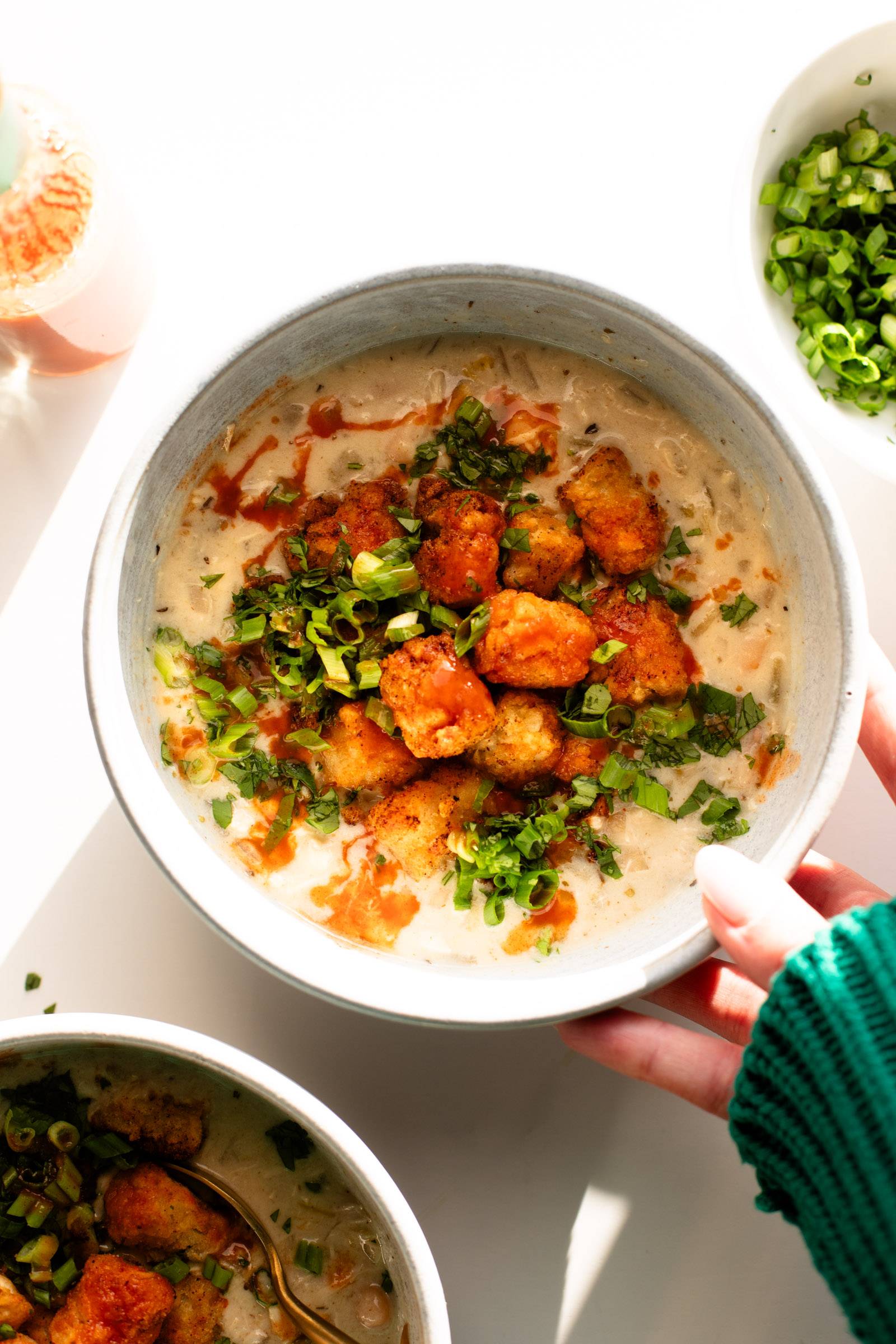 Extra Creamy White Chicken Chili topped with golden crispy tots!