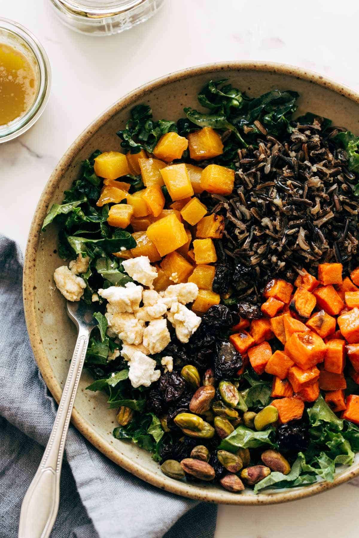 Grain bowl with rice, veggies, nuts, and cheese.