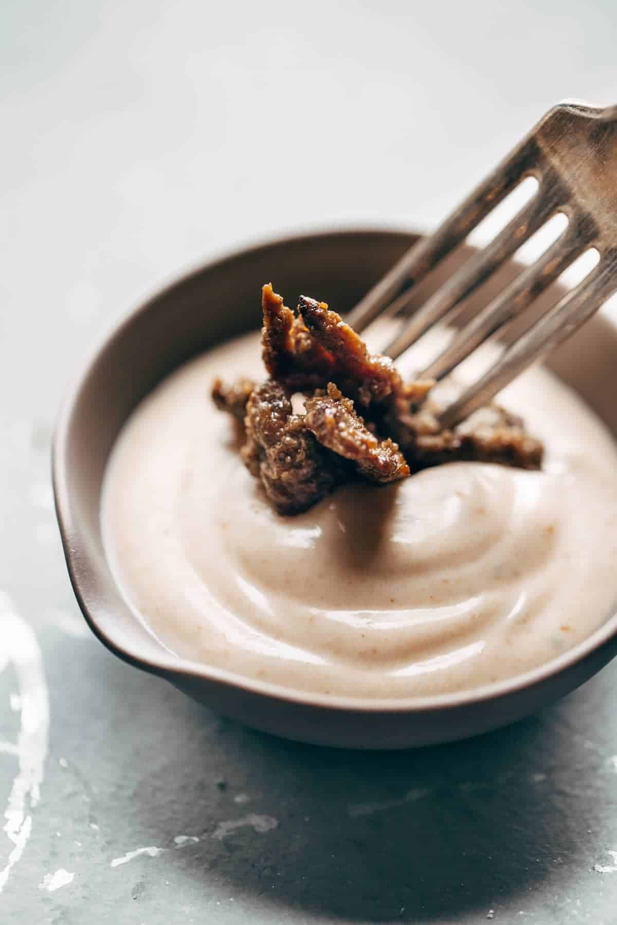 sauce in a bowl with a fork dipping food 