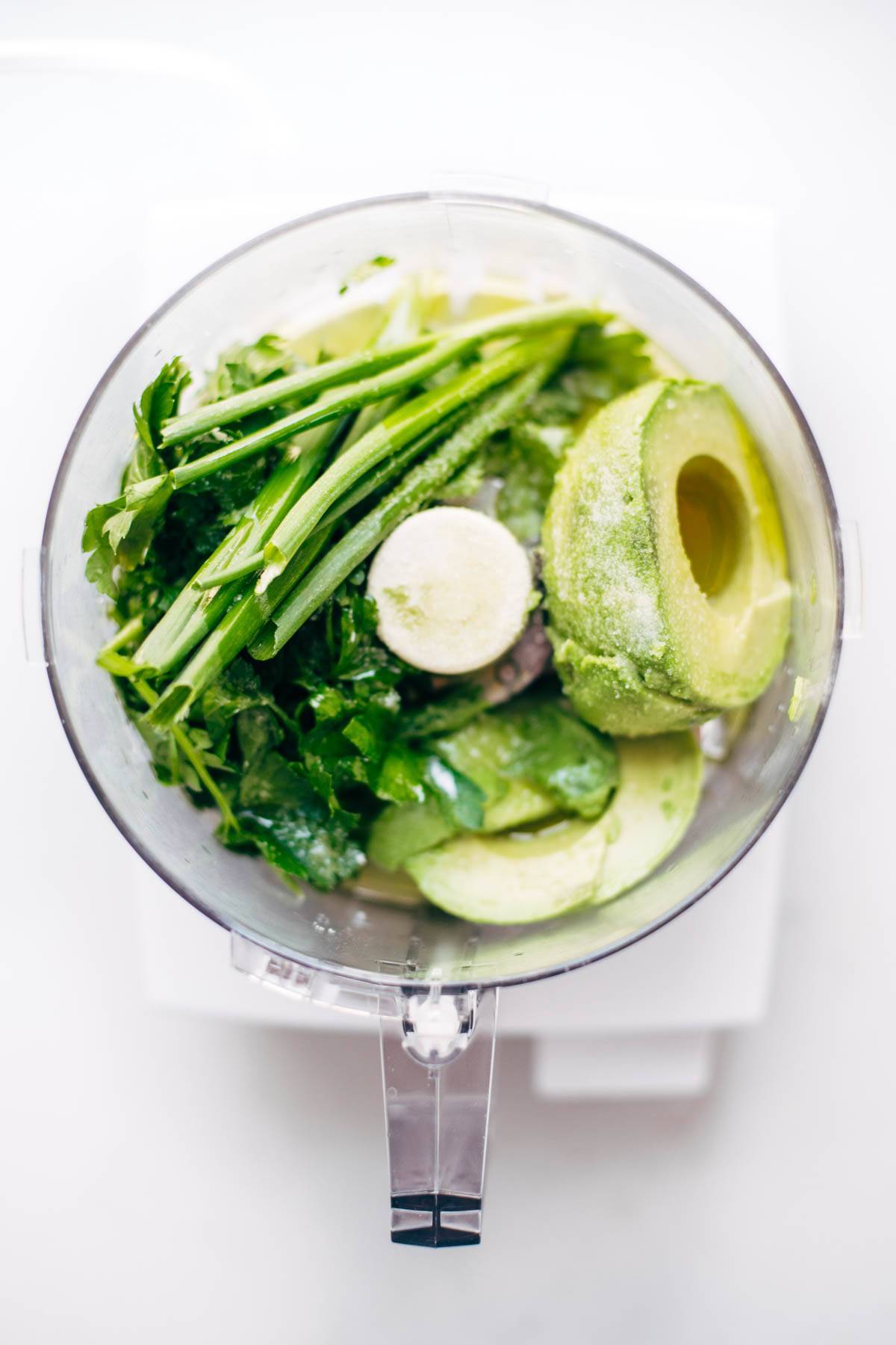 Onions, cilantro, and avocado in a food processor.