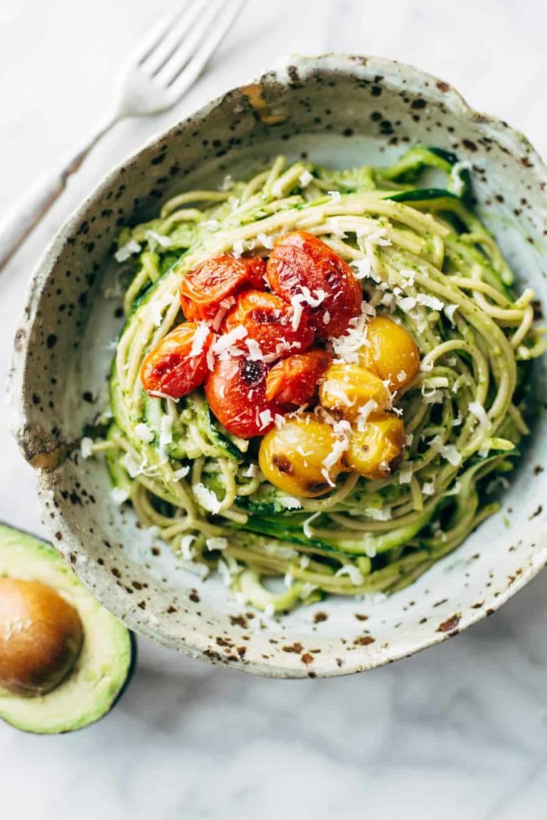 Zucchini noodles and spaghetti with roasted tomatoes on top.