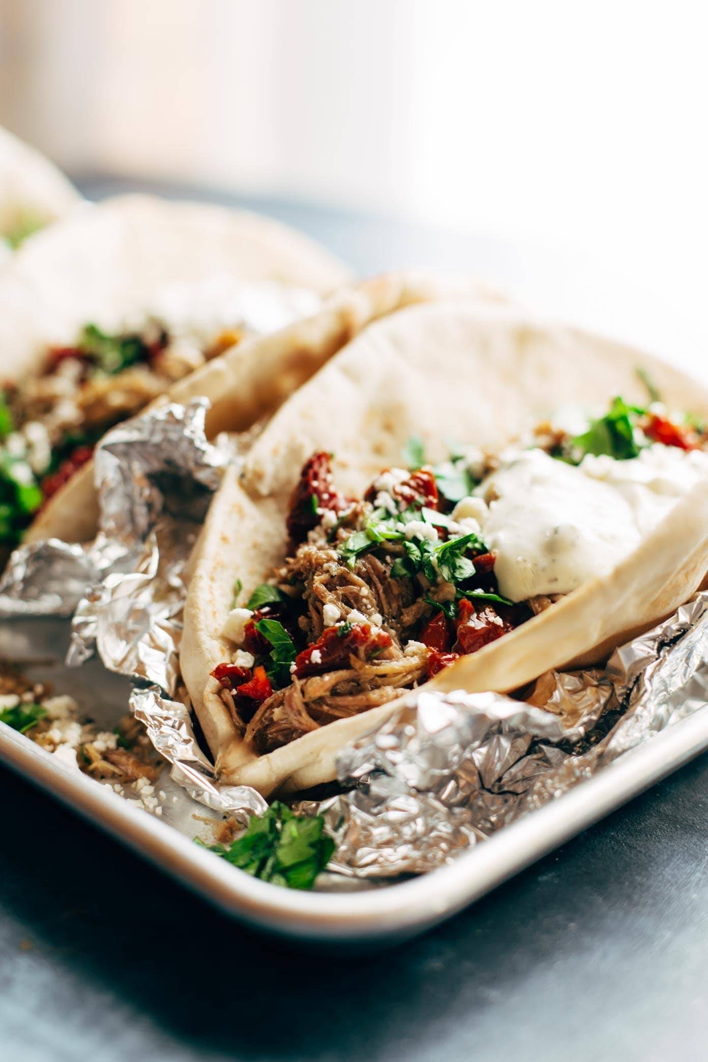 Everything Greek Pork Pitas on a tray with tin foil.