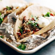 Greek Pork Pitas in foil on a pan.