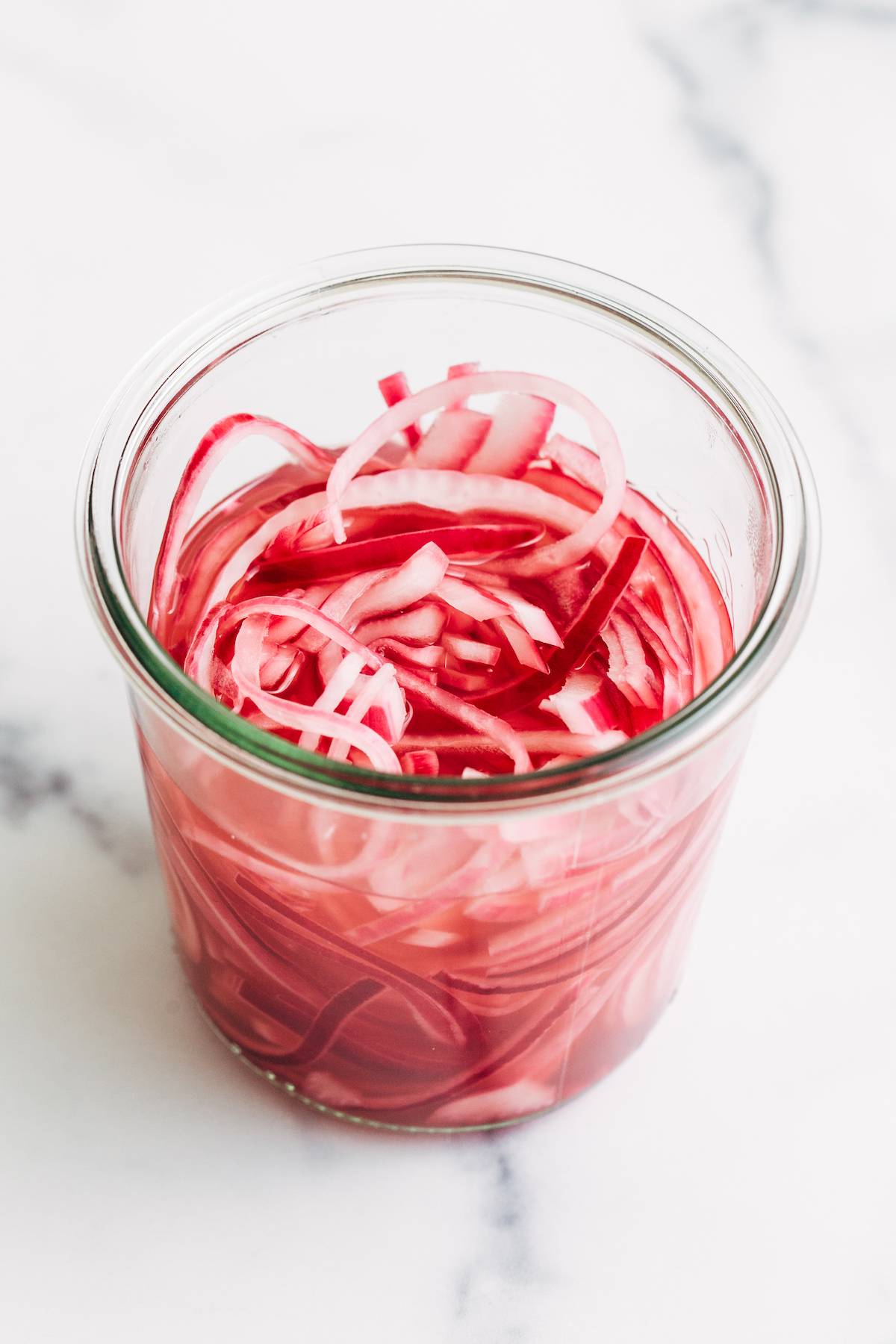 Pickled red onions in a jar.