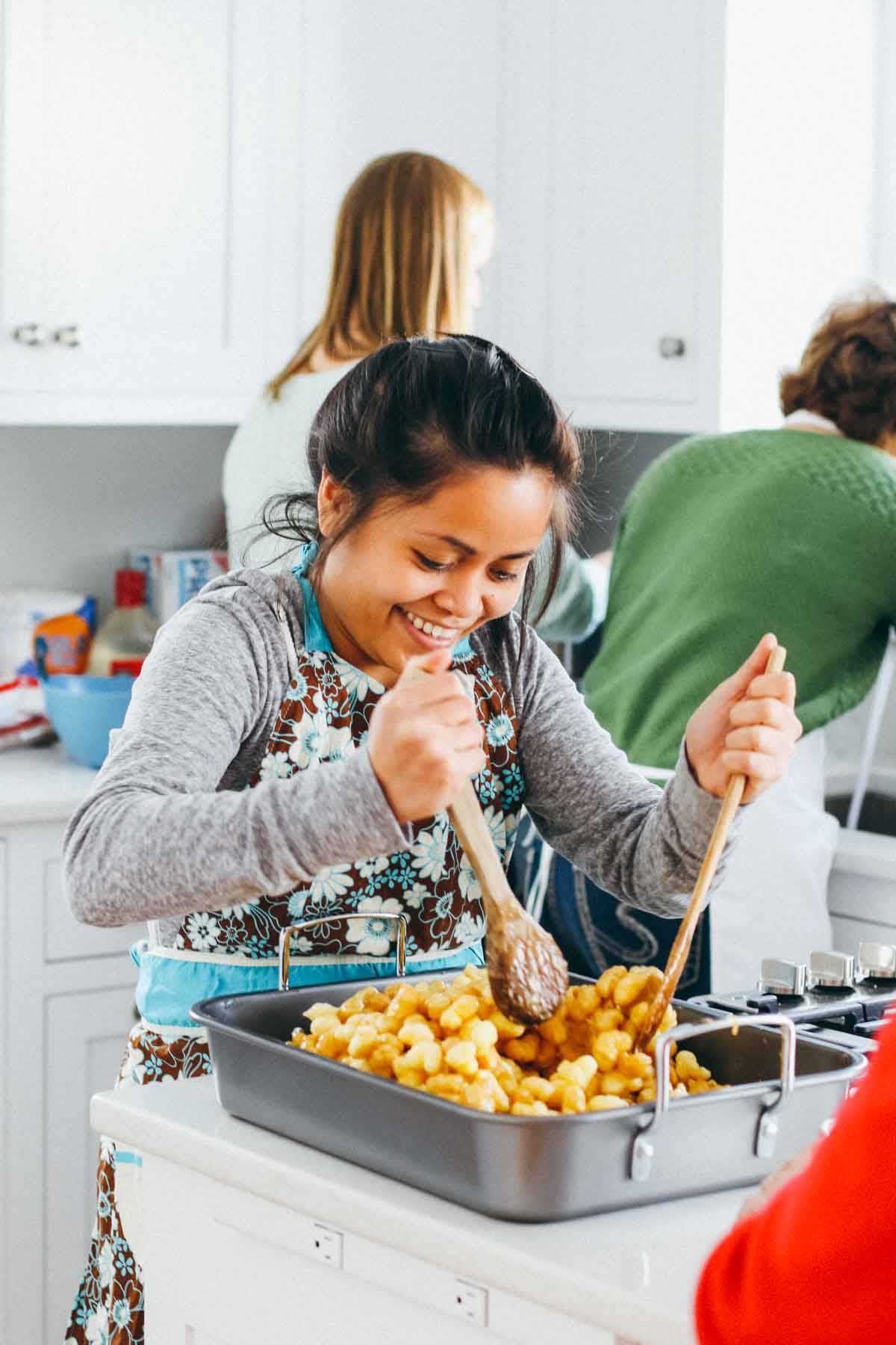 Girl stirring caramel popcorn.