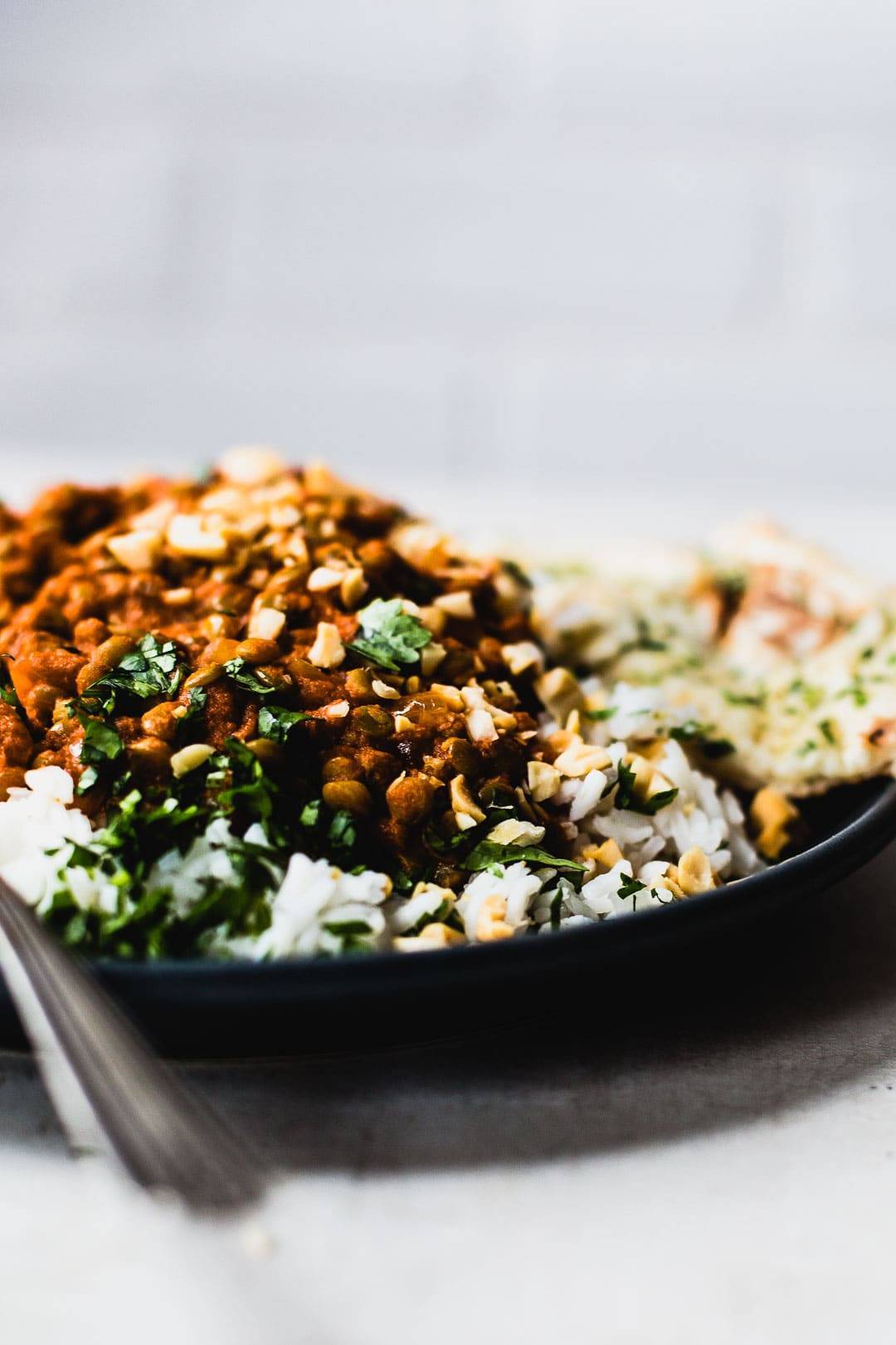 Red curry lentils on plate with rice.