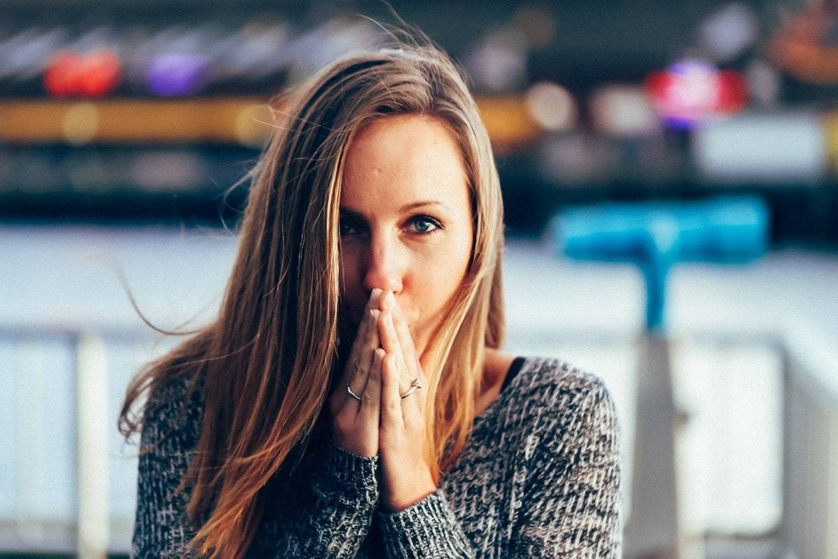 Woman with hands over her mouth.