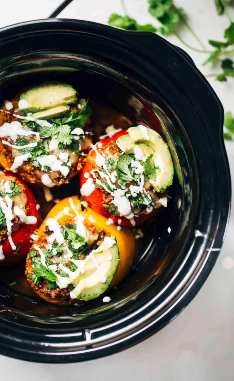 Stuffed Quinoa peppers and avocado slices in a crockpot.