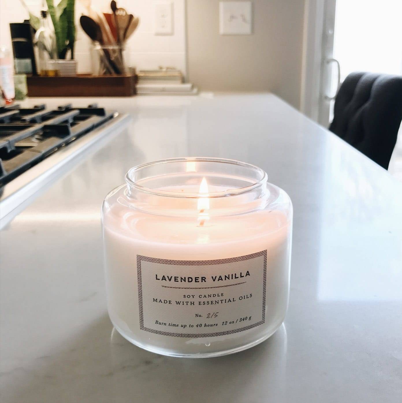 A white candle burning on the counter.